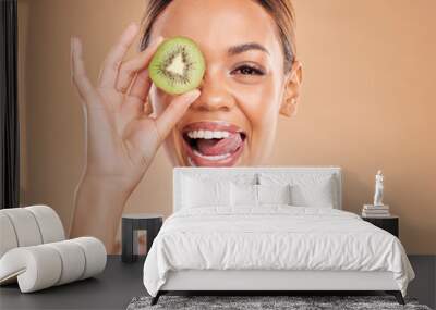 Skincare, kiwi and portrait of woman with smile in studio for wellness, organic facial and natural cosmetics. Beauty, dermatology spa and happy face girl with fruit for detox, vitamin c and nutrients Wall mural