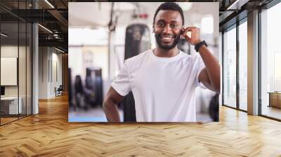 Portrait of black man, personal trainer at gym and workout athlete ready for fitness exercise, healthy body and a wellness training. Face of strength, muscle development and a physical health coach Wall mural