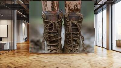 person wearing muddy boots standing in a muddy area Wall mural