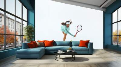 Athletic female tennis player in light blue sports attire strikes forehand shot against white studio background. Concept of professional sport, championship, active lifestyle, tournament. Ad Wall mural