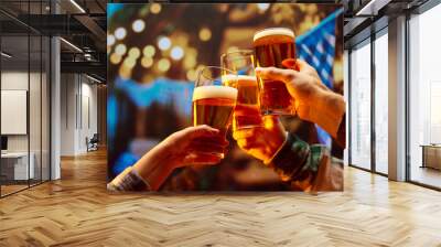 Close up image of hands holding glasses of beer and clinking after celebrating toast. Old friends sitting in bar and celebrating start of football season. Concept of Oktoberfest, party, traditions. Wall mural