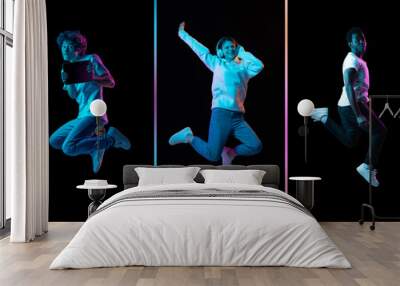 Collage of young men and women jumping isolated on dack background in neon. Flyer Wall mural