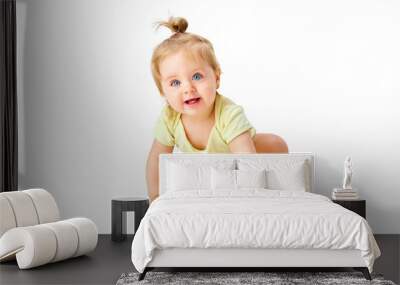 Curious little baby girl, toddler crawling forward and attentively looking with interest against white studio background Wall mural