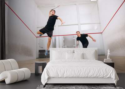 Full-length portrait of two young sportive boys training together, playing squash isolated over sport studio background Wall mural