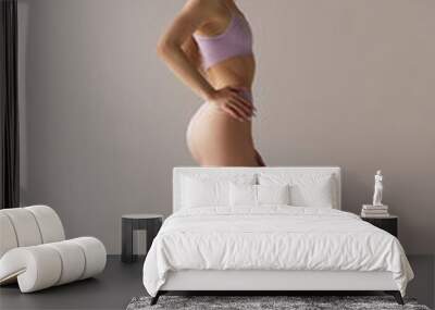 Full-length side view portrait of young slim girl posing in underwear against grey studio background. Taking care after body shape Wall mural