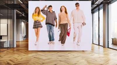 Group of beautiful young people. students in stylish clothes walking, posing over grey background. Start of educational year Wall mural