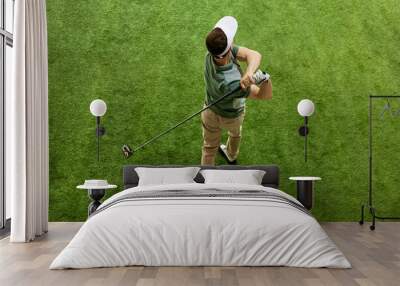 High overhead angle view of skilled golfer in casual attire hitting golf ball on fairway green grass. Concept of professional sport, luxury games, active lifestyle, action. Ad Wall mural