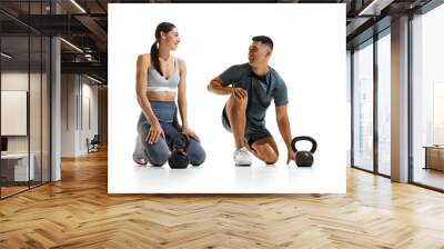 Portrait of man and woman taking break from their workout, kneeling on floor and smiling at each other against white studio background. Concept of people in sport, healthy lifestyle, teamwork. Ad Wall mural