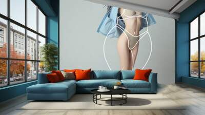 Portrait of slim woman in underwear wear and shirt posing isolated over gray studio background. Lines around body before losing weight. Wall mural