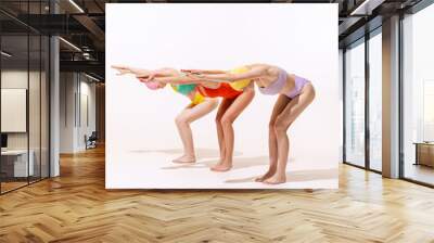 Portrait of three young women in vintage retro swimming suits posing isolated over grey studio background. Ready to dive. Wall mural