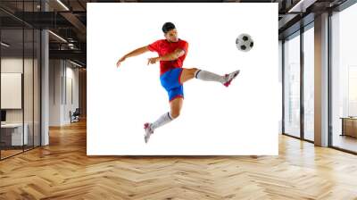 Portrait of young man in uniform, professional football player kicking ball in a jump isolated over white studio background. Wall mural