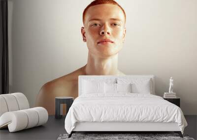 Portrait of young red-haired man posing shirtless isolated over grey studio background. Freckled face Wall mural