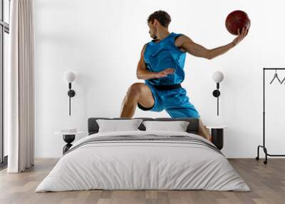 Young caucasian professional basketball player exercising with ball isolated on white background Wall mural