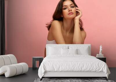 Young tall thin girl with long soft brown hair wearing white inner wear posing over pink color background. Concept of natural beauty, body and skin care, healthy eating Wall mural