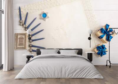 Jewish holiday Hanukkah concept with white napkin, menorah, Torah and gift box over white wooden background Wall mural