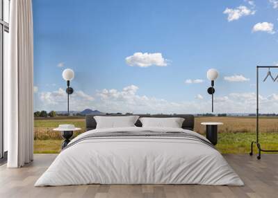 Green field under a blue sky with clouds and hills in the background. Tandilia, Provincia de Buenos Aires, Argentina. Copy space. Wall mural