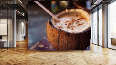 A refreshing coconut drink with a straw. Wall mural