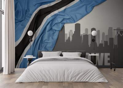 abstract silhouette of the city with text Serowe near waving colorful national flag of botswana on a gray background. Wall mural