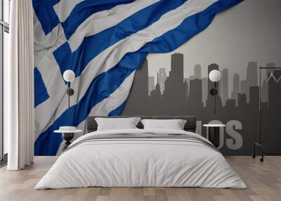 abstract silhouette of the city with text Volos near waving national flag of greece on a gray background. Wall mural