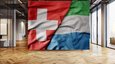 big waving national colorful flag of switzerland and national flag of sierra leone . Wall mural