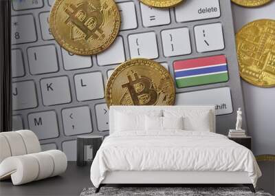 national flag of gambia on the keyboard with bitcoin coins on a grey background. Wall mural