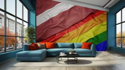 waving colorful gay rainbow flag and national flag of latvia. Wall mural