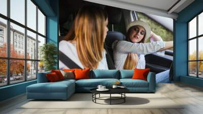 Two young girls have fun chatting inside the car Wall mural