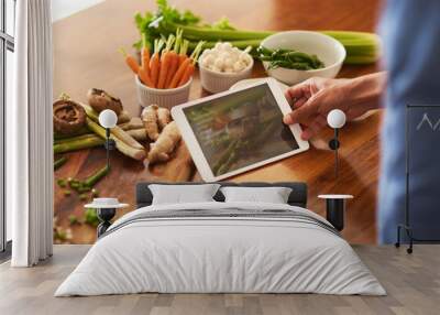 Recipes go paperless. Cropped shot of a man using a digital tablet while preparing a healthy meal at home. Wall mural