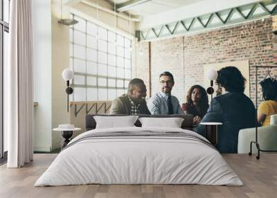 Every idea is worth listening to. Shot of a diverse group of businesspeople having a meeting around a table in their office. Wall mural