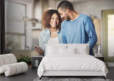 I found the perfect recipe. Shot of a happy young couple using a digital tablet while preparing a healthy meal together at home. Wall mural