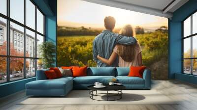 Look at what weve accomplished. Shot of a young couple walking through their crops while holding each other and looking into the horizon. Wall mural