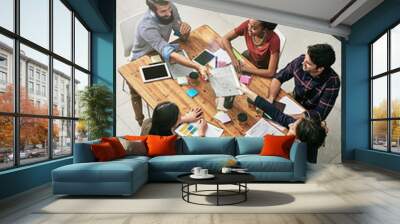 Passing around important paperwork. High angle shot of a group of colleagues having a meeting in a modern office. Wall mural