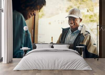 Signed and delivered. Shot of a cheerful young woman signing a form after receiving a package from a delivery man at home during the day. Wall mural