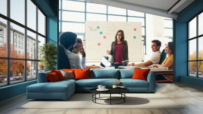 We are here to create and contribute. Shot of creative employees having a meeting in a modern office. Wall mural