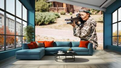 Boy looking into the optical sight a weapon. Children playing laser tag shooting game in outdoor. War simulation game Wall mural