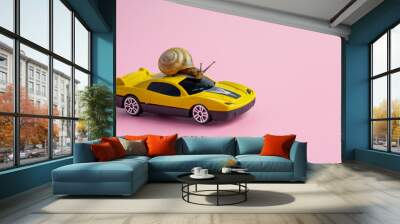 Speedy snail like car racer. Concept of speed and success. Concept of fast taxi or delivery. Yellow race car on light pink background. Copy space Wall mural