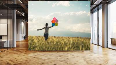 Cheering young asian woman on grassland with colored balloons Wall mural