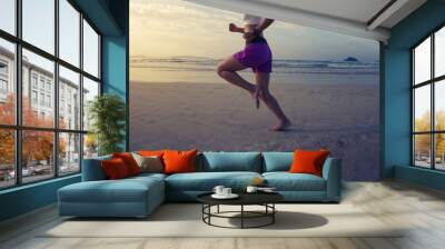 Fitness woman runner running on sunrise beach Wall mural