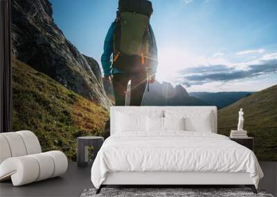 Solo woman backpacker hiking on alpine mountain peak Wall mural