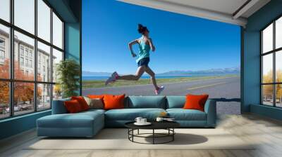 Young fitness woman runner running on sunrise seaside trail Wall mural