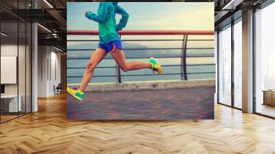 young fitness woman running at seaside Wall mural