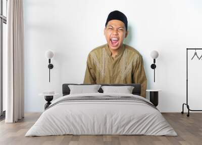 angry asian muslim male screaming with grabbing hand looking at camera isolated on white background Wall mural