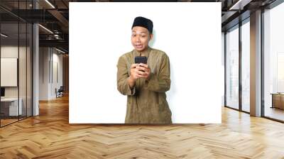 funny asian muslim man using smartphone isolated on white background Wall mural