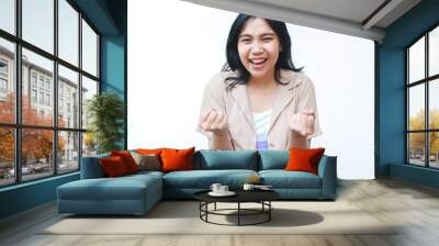 happy asian woman celebrate victory with raised fist wearing casual brown clothes isolated on white background Wall mural