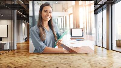 Portrait, creative and smile with a designer woman at work in her office boardroom on a project. Marketing, design and happy with a young female employee working at a table or desk for advertising Wall mural