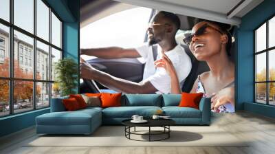 Freedom, travel and couple on a car road trip happy, singing music and driving. Black woman and man from Kenya relax traveling on a summer vacation or holiday on mobile transportation with a smile Wall mural