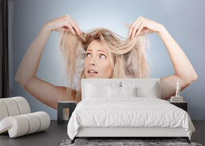 Hair care, stress and woman sad about frizz, split ends and messy style against a grey studio background. Frustrated, unhappy and angry model with problem with her hair, frustration and worry Wall mural