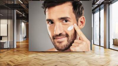 Portrait, skincare and man with face cream in studio for moisturizing on gray background mockup. Beauty, male and model from Canada apply cosmetics product, facial creme or lotion for healthy skin. Wall mural