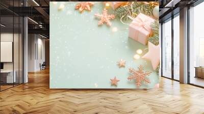 Festive Christmas decorations with pastel colors, sparkling stars, and gift boxes on a mint green background Wall mural