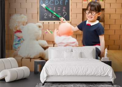 toddler girl pretend play as a teacher at home Wall mural